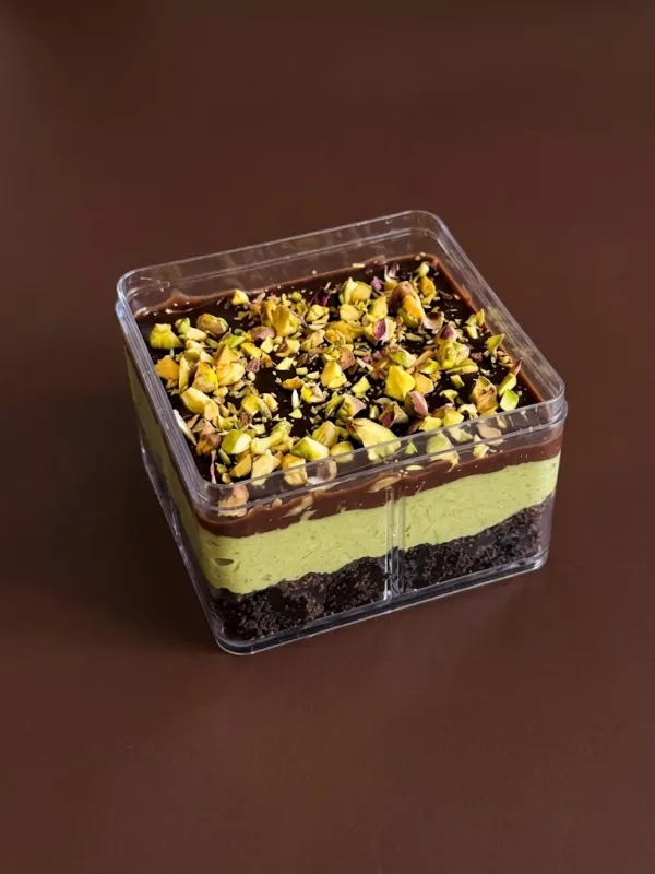 Pistachio dessert tub with layers of brownie, pistachio cream and chocolate